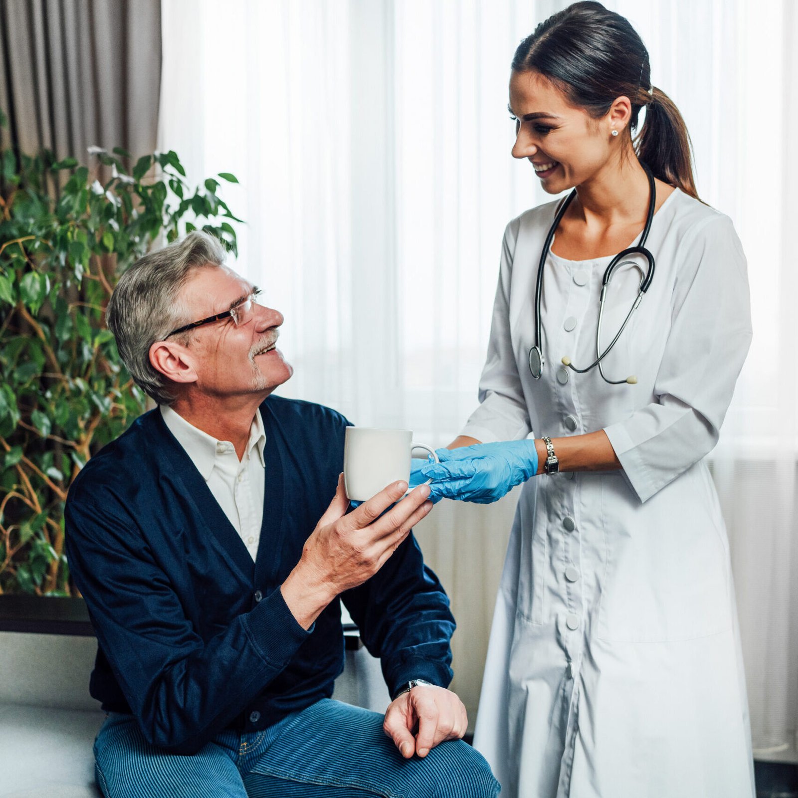 Photo of a happy female doctor giving water to her patient, a nu